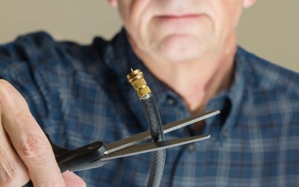 Cutting the cable connection to coax connector illustrating retired people cancelling cable TV service