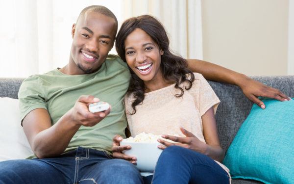 couple sitting on couch watching tv