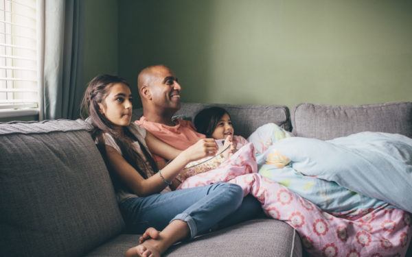 dad and daughters watching tv
